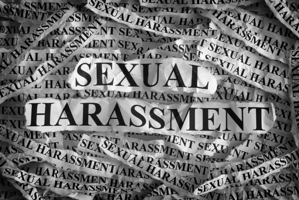 Sexual harassment. Torn pieces of paper with the words sexual harassment. Concept Image. Black and White. Closeup.