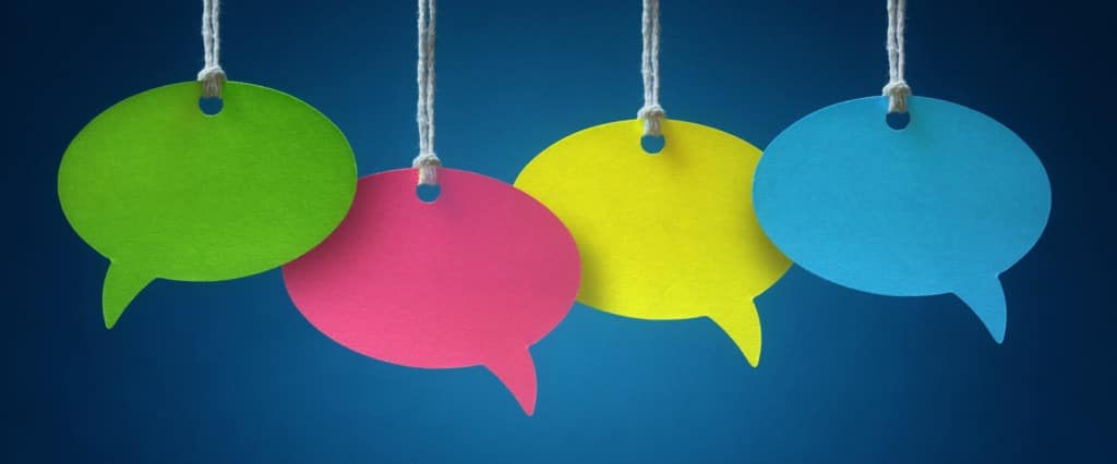 Blank colorful speech bubbles hanging from a cord over blue background