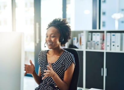 Woman in office with headset working in virtual leasing