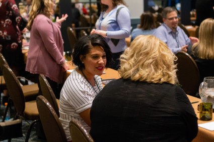 two women conversing at a conference