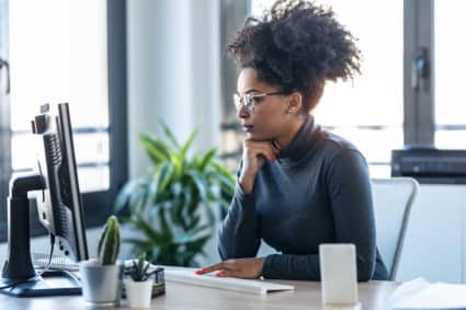 Shot of young business woman working while making video call with computer sitting in the office.