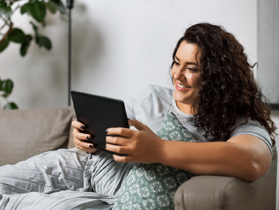 image of a resident relaxing, taking a survey on their tablet or laptop.