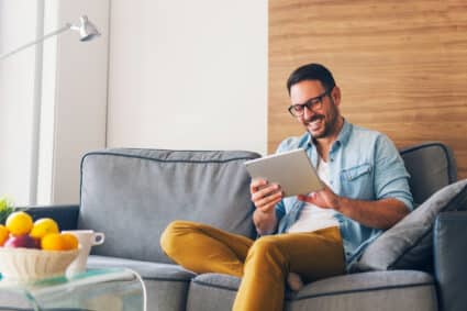 Man sitting on a couch and smiling.