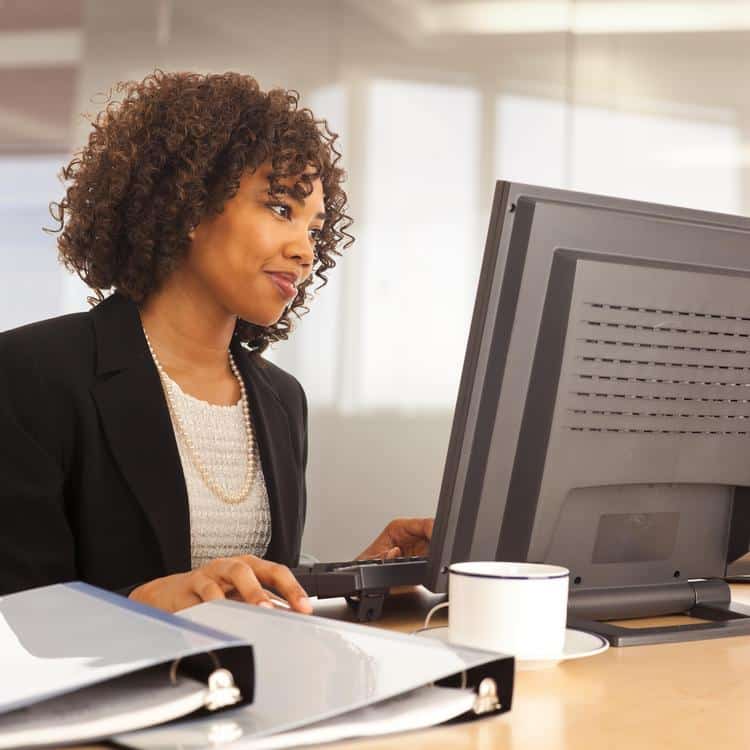 Young businesswoman using computer at desk indoors office building