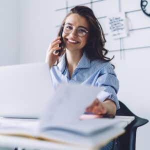 Leasing agent smiling on the telephone at her desk.