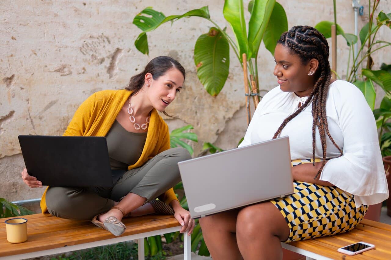 Two women working on laptops together