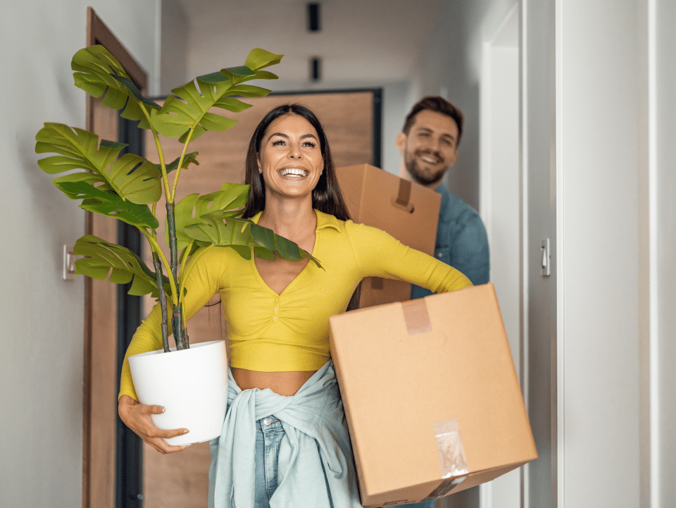 Couple holding boxes to move into new apartment.