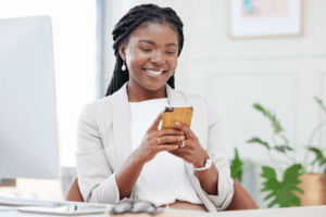 woman smiling looking at her smart phone