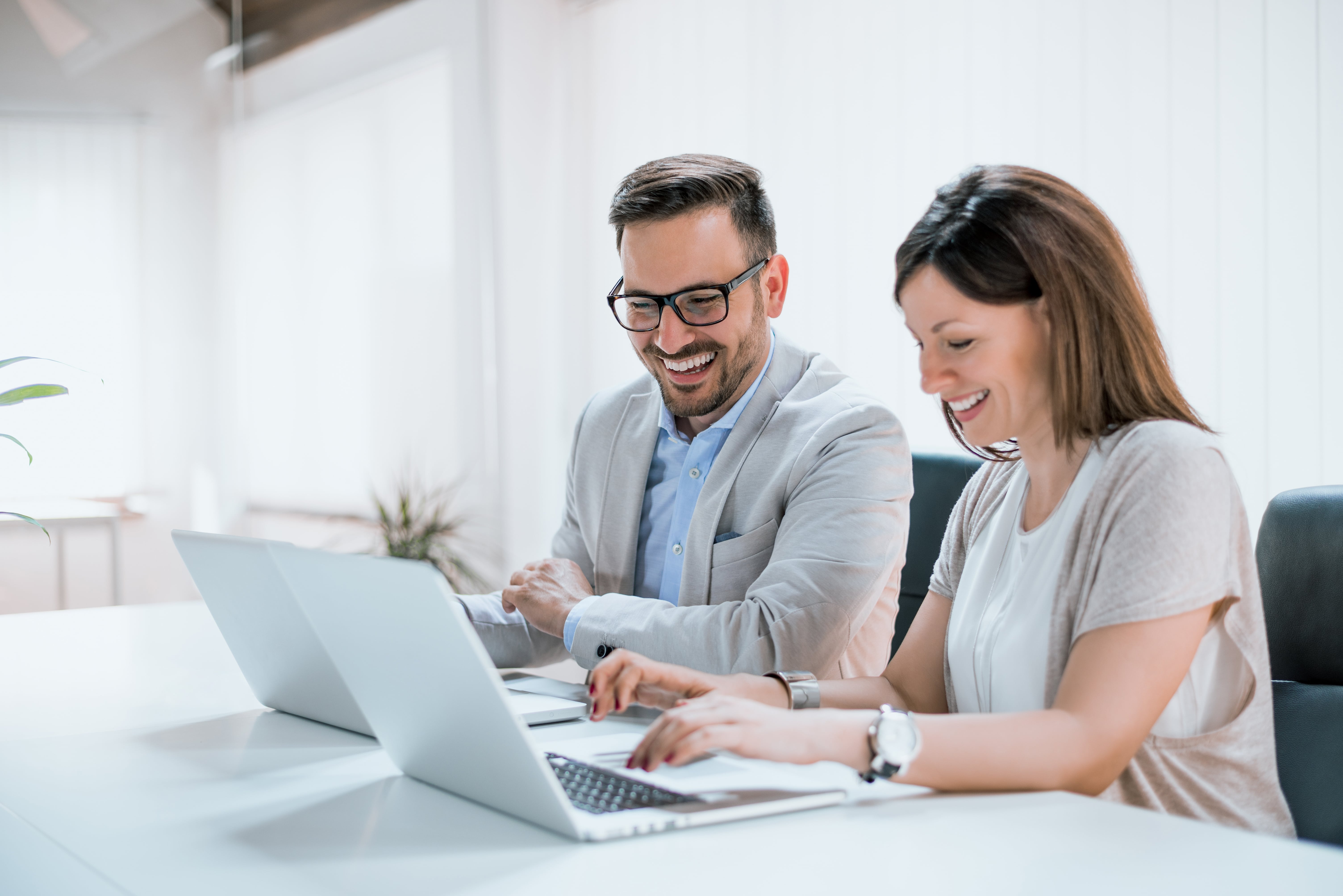 property manager man and woman smiling at desktop