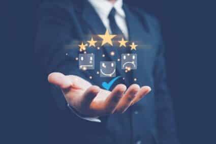 business man holding hand out with symbols representing ratings, resident satisfaction levels above