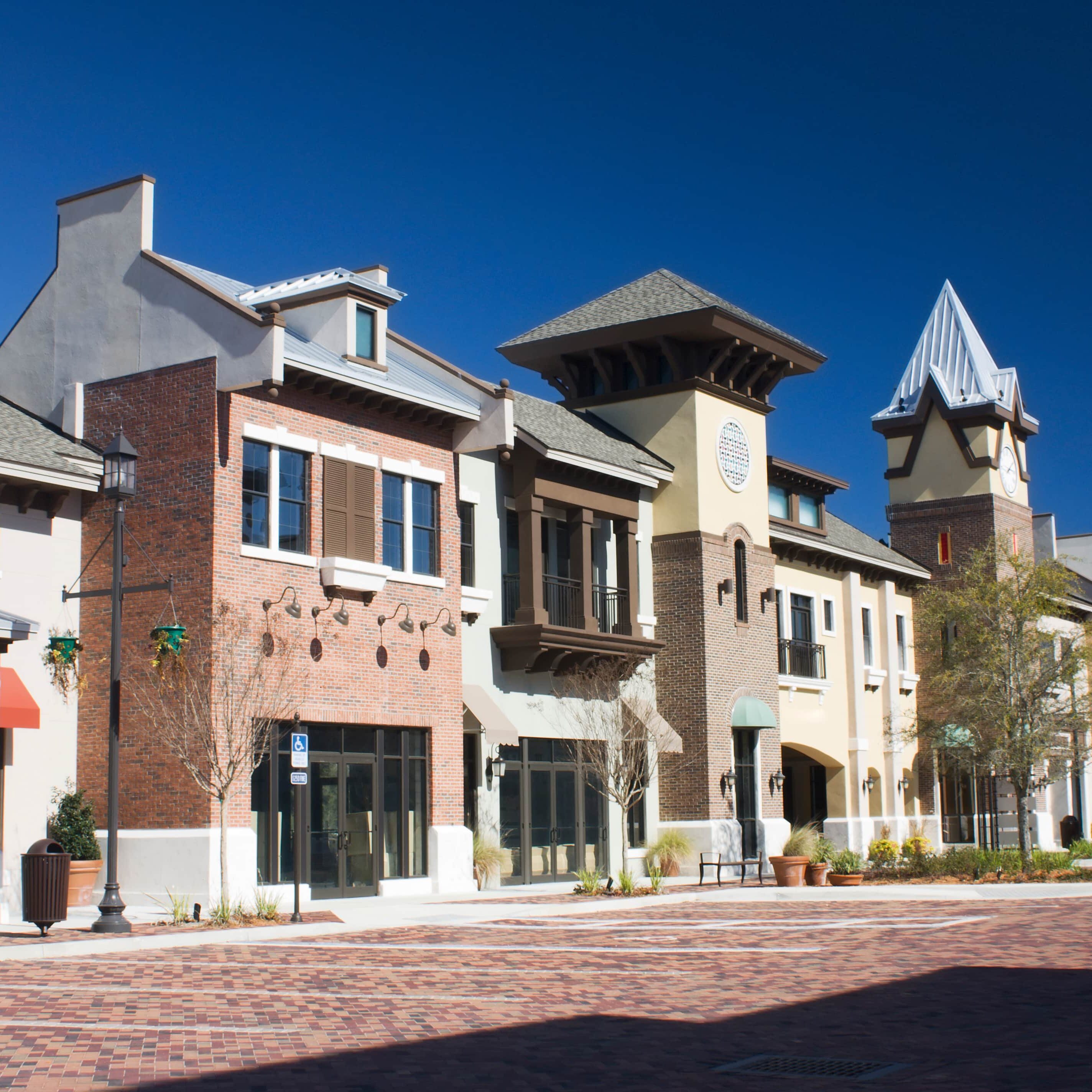 upscale shopping plaza mixed architecture styles commercial strip mall with brick paver parking