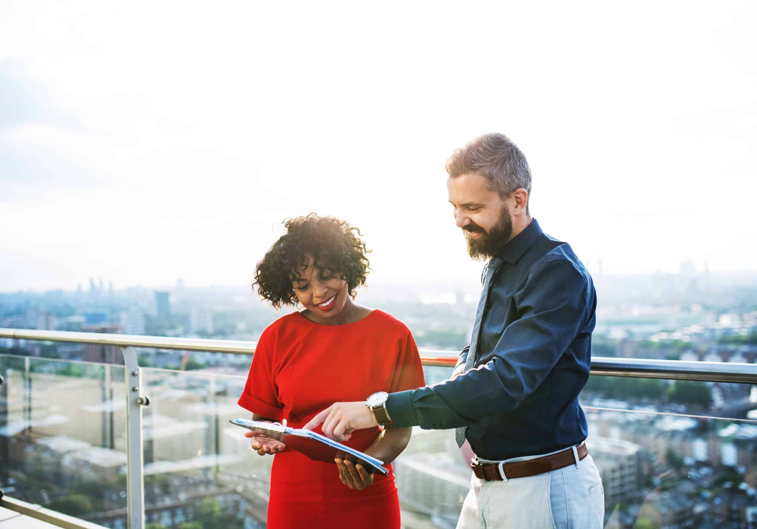 A portrait of a tenant and property manager standing against London view panorama