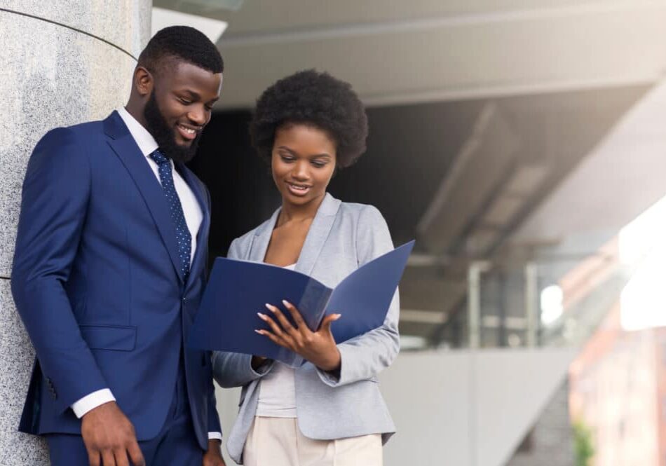 Successful african american business partners checking financial reports outdoors, copy space