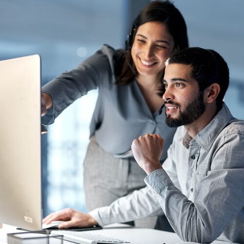 Employee Needs Surveys Call center, manager and telemarketing team at computer for software training, customer service and CRM in office at night. Man, woman and sales mentor helping intern on desktop for technical support